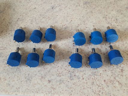 Zwölf blaue Potentiometer auf Arbeitsfläche