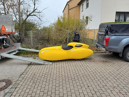 Gelbes Liegerad auf einem Anhänger