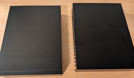 Zwei schwarze Gehäuse auf Holztisch