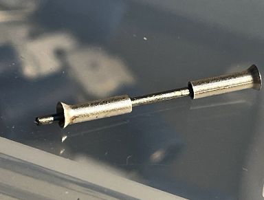 Metallischer Zylinder oder Bauteil auf glatter Oberfläche