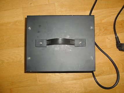 Schwarzes Gehäuse mit Tragegriff und Netzkabel